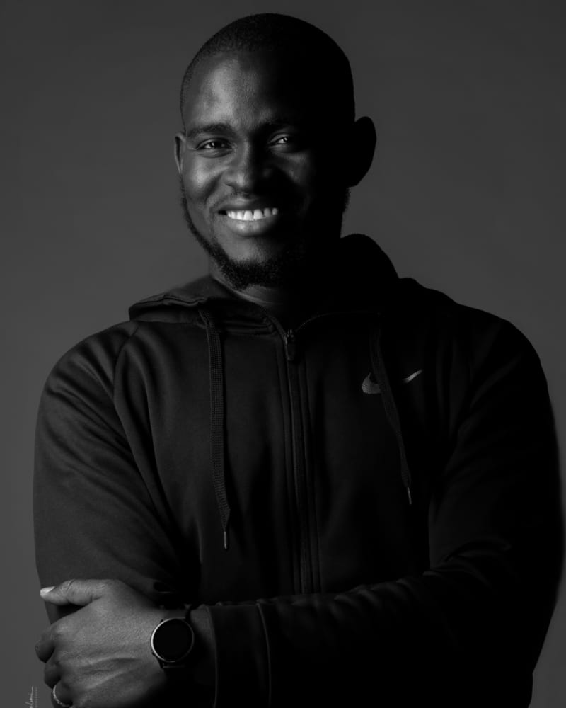 Portrait d’Ibrahima, bras croisés, en noir et blanc.